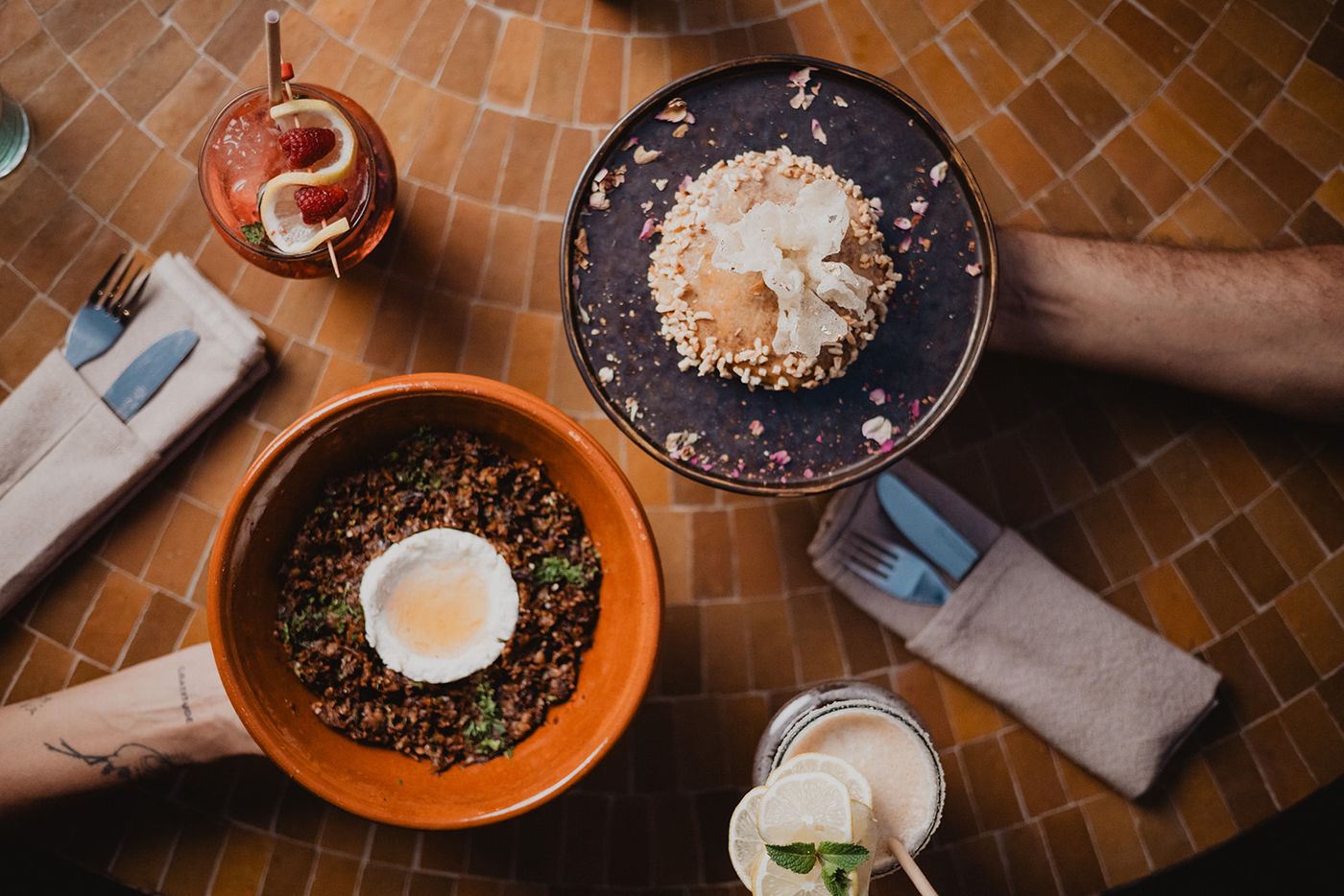 Overhead view of a zellige table with shared dishes